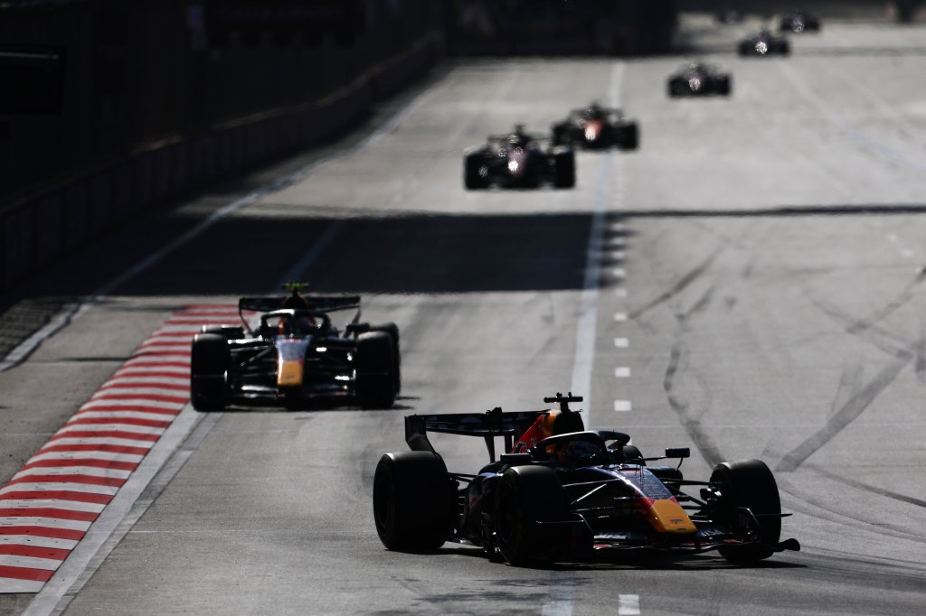 Formel-1-Rennen auf der Strecke mit mehreren Rennwagen in Bewegung auf einer sonnigen Piste.